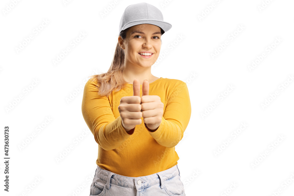 Cheerful young female with a yellow top and cap gesturing thumbs up with both hands Cheerful young female with a yellow top and cap gesturing thumbs up with both hands