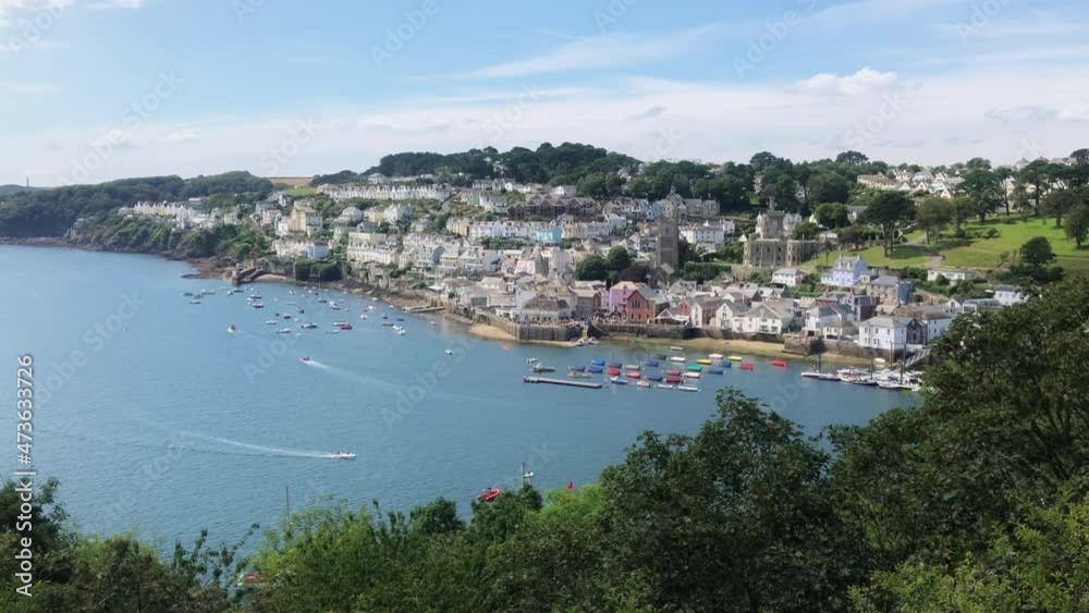 Summer View of a British Town with the River Fowey Estuary in Cornwall with Boats and a View of the Housing Along the Coast. Summer View of a British Town with the River Fowey Estuary in Cornwall with Boats and a View of the Housing Along the Coast.