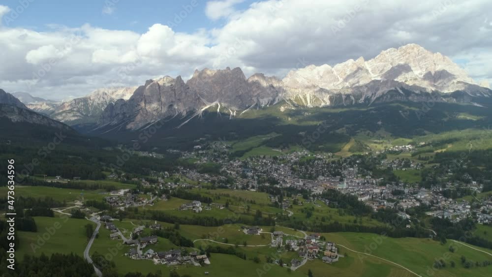 Aerial Forward Scenic Shot Of Houses On Green Landscape Against Cloudy Sky - Dolomites, Italy