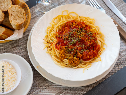 Appetizing Italian spaghetti with ground meat based bolognese sauce seasoned with aromatic dried herbs served for dinner. Authentic cuisine