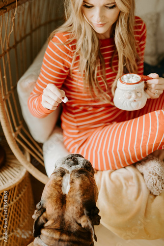 A woman decorating her apartment for Christmas with her pets photo