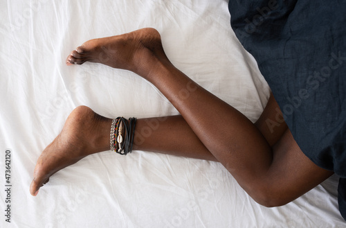 Barefoot black woman on bed photo