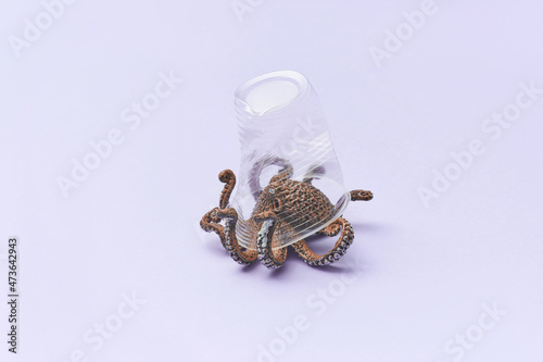Toy octopus under transparent plastic glass photo