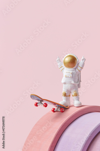 Spacemen riding skateboard on pink background photo