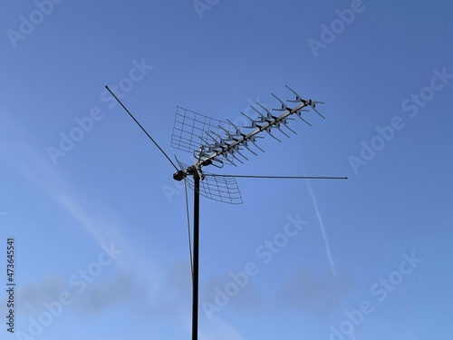 Tv antenna outdoor on the roof. Antennas home TV on blue sky. Close up antenna with copy space for design or text.