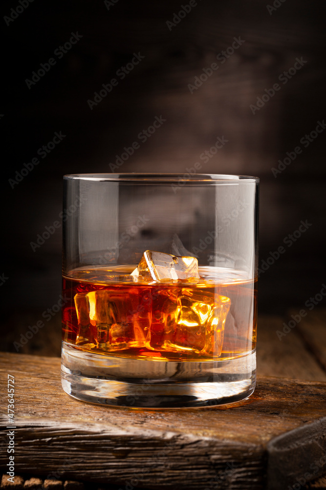Glass with whiskey and ice cubes. Glass with whiskey and ice cubes.