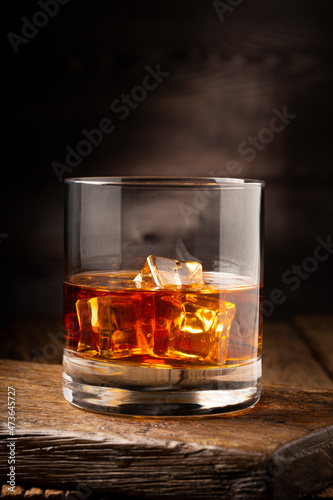 Glass with whiskey and ice cubes.