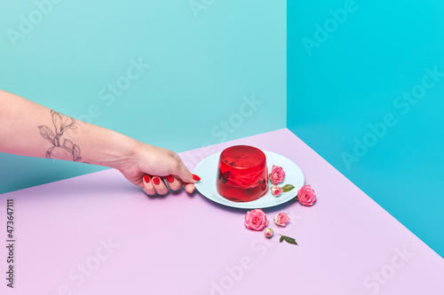 Female hand putting a plate with jelly dessert photo