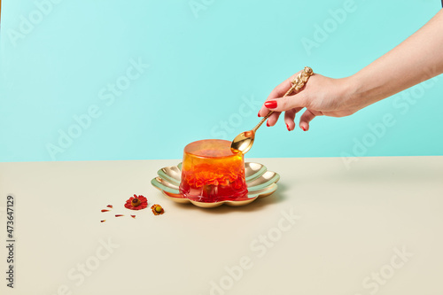 Crop female eating gelatin dessert photo