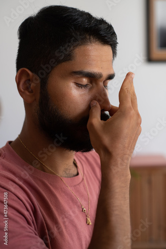 Man holding his nose during a pranayama breath practice photo