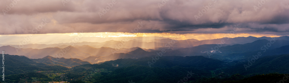 sunset sky with fog and rainy clouds raining over the Majestic mountains landscape