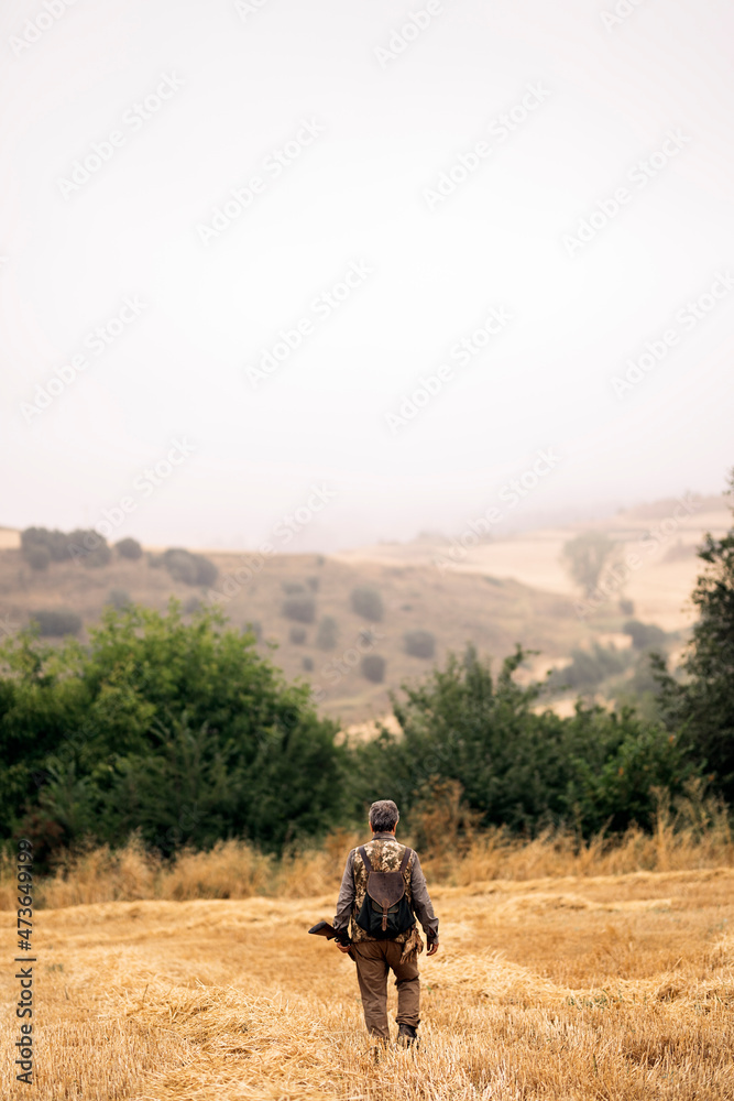 Bird hunter walking through the field Bird hunter walking through the field