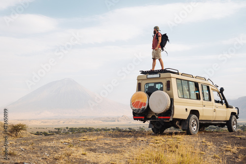 Man on the top of a safari car photo