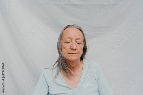 Senior woman over white background and eyes closed