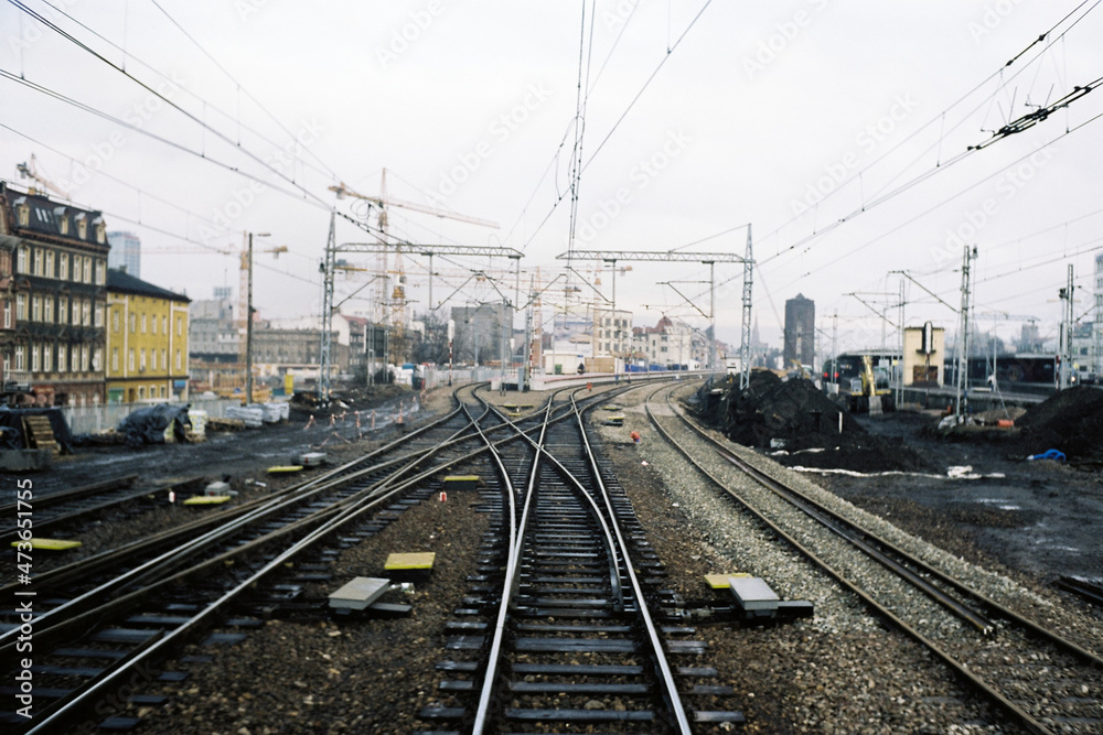 Empty train tracks in a industrial town during grey day Empty train tracks in a industrial town during grey day