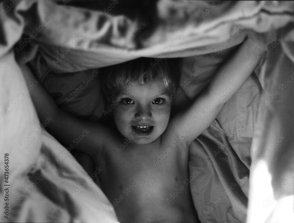 A beautiful 3 years old boy under bed sheets A beautiful 3 years old boy under bed sheets