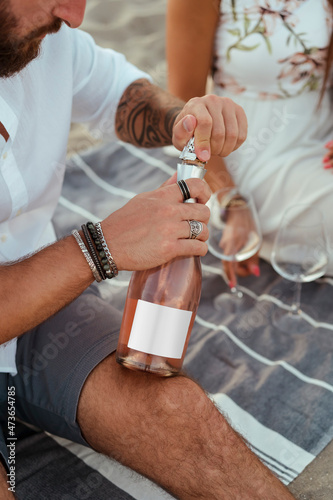 Man opening a bottle of wine to celebrate
