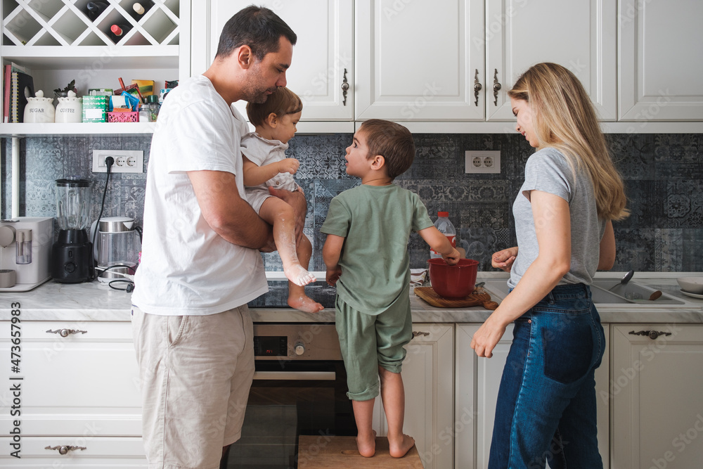 A Family Of Four Together In The Kitchen A Family Of Four Together In The Kitchen