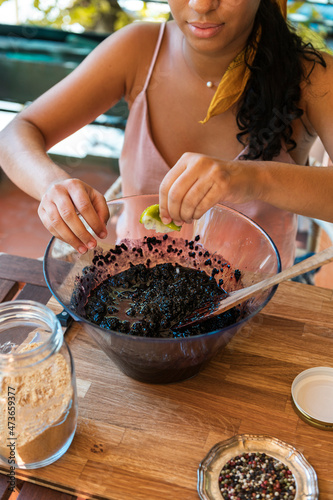 Female adding lime juice to homemade jam