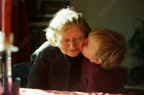 A grandchild kissing his granny