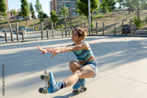 Roller-skate in skate park keeping balance on one foot photo