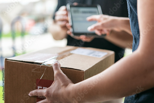 Shipment: Woman Signs For Delivery On Tablet photo