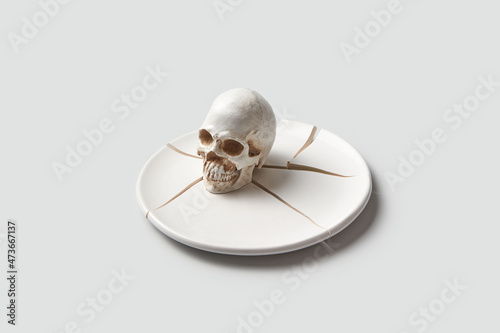 Human skull on broken plate photo