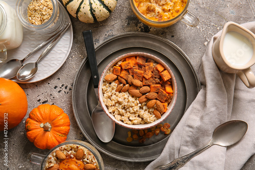 Bowl of tasty oatmeal with pumpkin and almond on grunge background