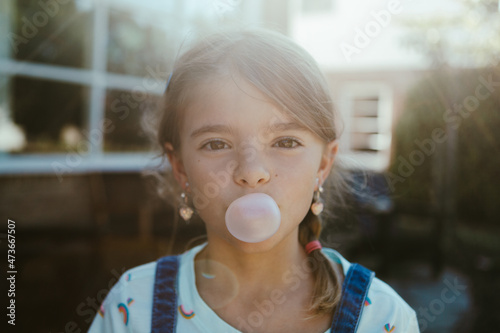 Portrait of child blowing a bubble with gum