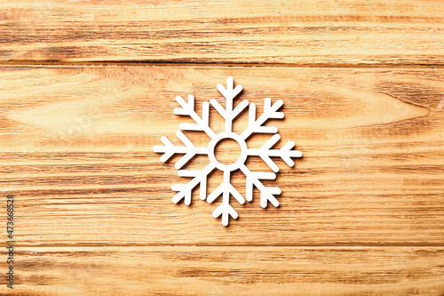Beautiful snowflake on wooden background