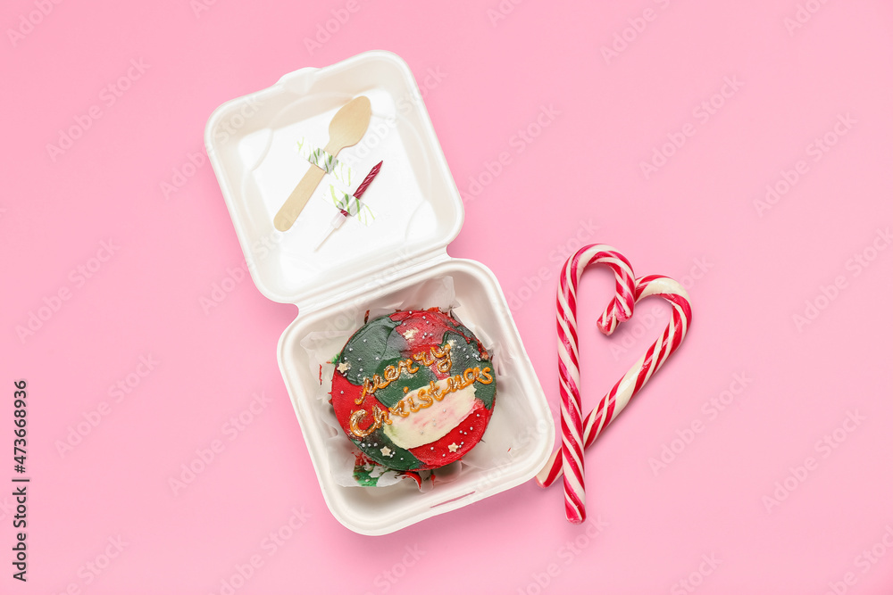 Plastic lunch box with Christmas bento cake and candies on pink background Plastic lunch box with Christmas bento cake and candies on pink background