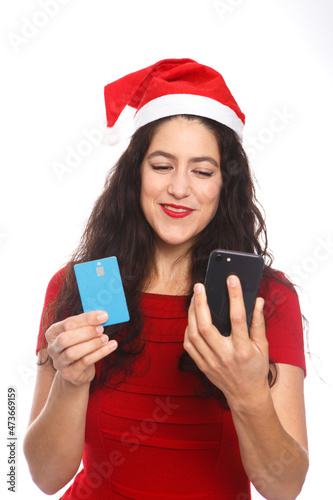 woman dressed in red dress and Santa hat  s holding a credit card and a mobile with a gesture