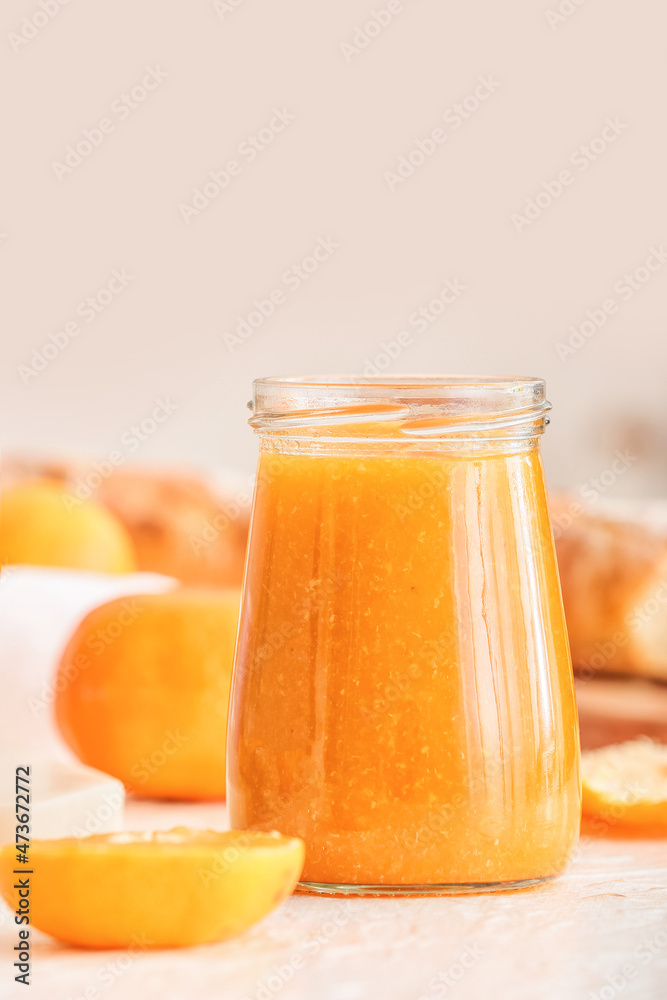 Jar of tasty tangerine jam on table, closeup Jar of tasty tangerine jam on table, closeup