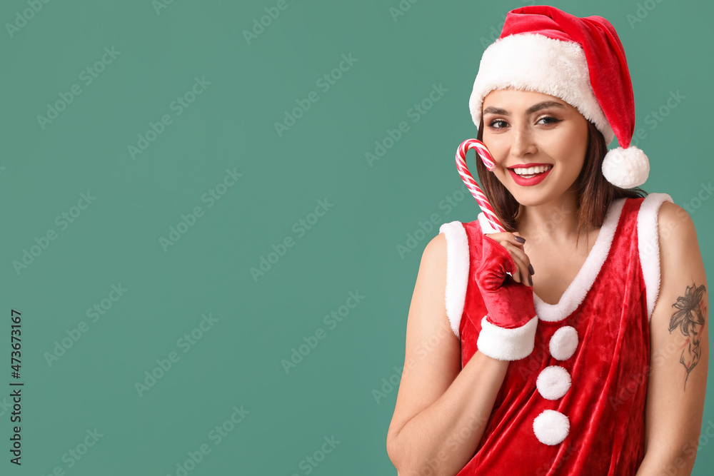 Sexy young woman in Santa costume and with candy cane on color background Sexy young woman in Santa costume and with candy cane on color background