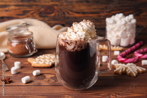 Glass cup of tasty hot chocolate on wooden background