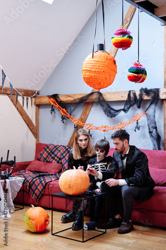 Father and son together painting Jack-o-lantern  photo