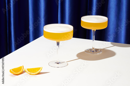 Whiskey Sour Cocktails on Table with Blue Drapes  photo