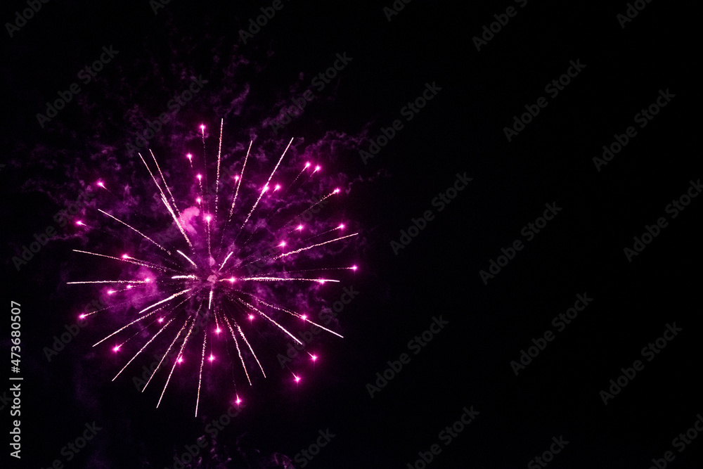 Obraz premium round fireworks and purple fireworks against the black sky. Christmas fireworks in the night sky. Christmas fireworks in the night sky