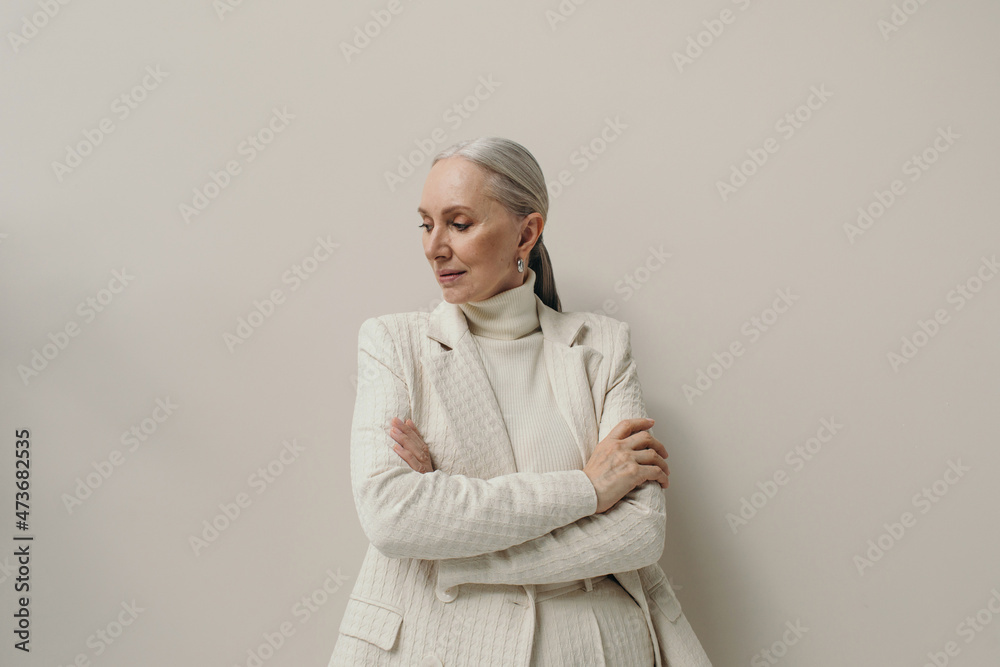 © Sergey Filimonov/Stocksy - Elegant senior woman with gray hair portrait in studio