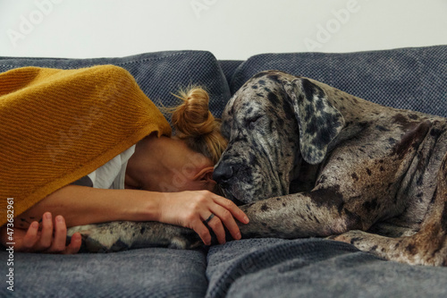 Woman and dog sleeping on couch photo