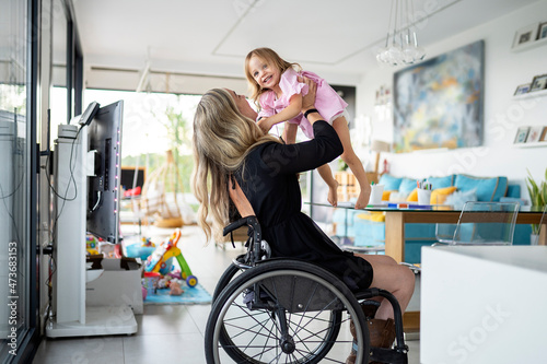 Mother in wheelchair playing with her daughter photo