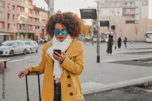  woman using smartphone at bus station photo