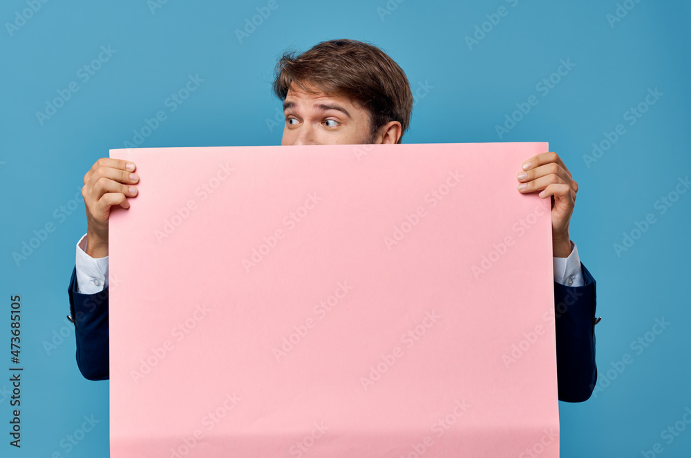 Cheerful man pink paper in the hands of marketing fun Lifestyle blue background Cheerful man pink paper in the hands of marketing fun Lifestyle blue background