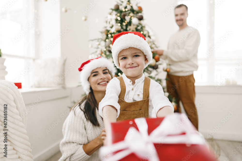 Parent and their little son having fun and playing together indoors at Christmas time Parent and their little son having fun and playing together indoors at Christmas time