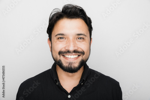Smiling South Asian Man against a white background.
