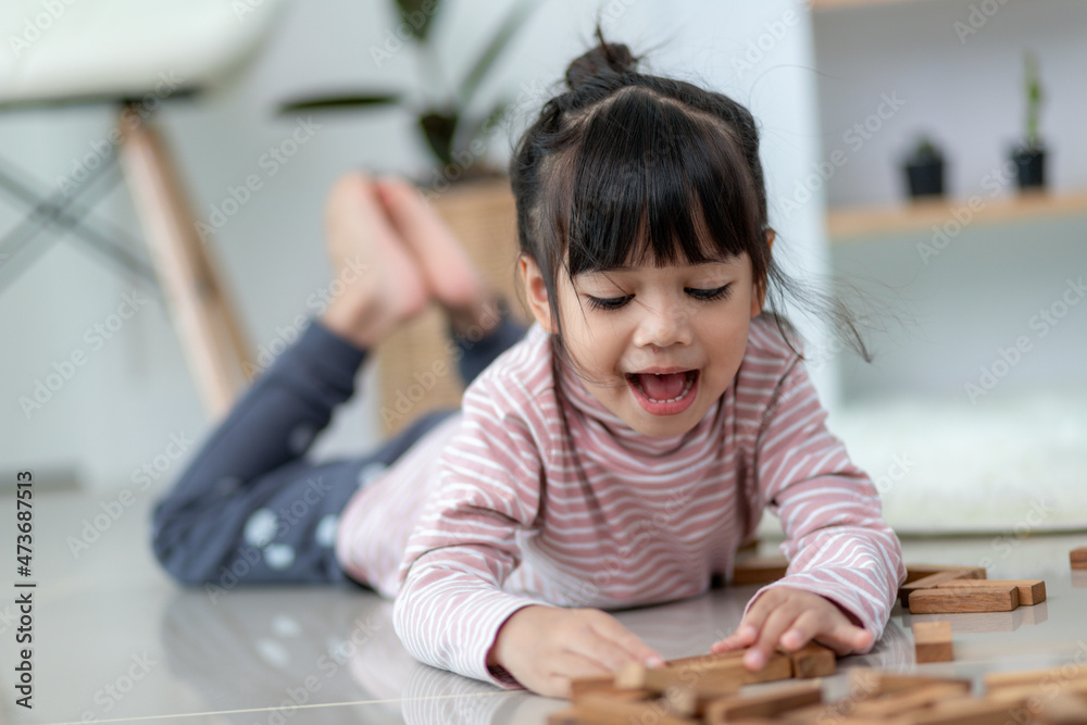 Asian sibling girl playing wooden stacks at home Asian sibling girl playing wooden stacks at home