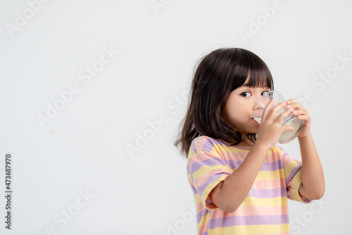 Smiling of Asian girl with a glass of milk