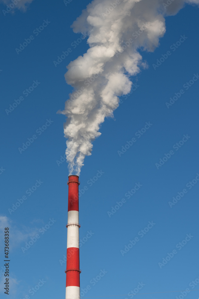 thick white smoke from the chimney against the blue sky