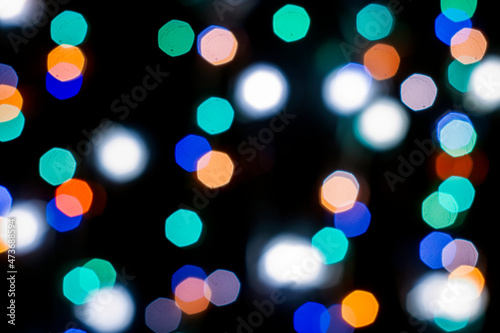 black abstract background with multicolored lights with bokeh in blur