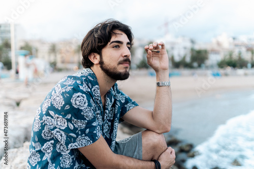 Young man smoking marihuana at the beach photo